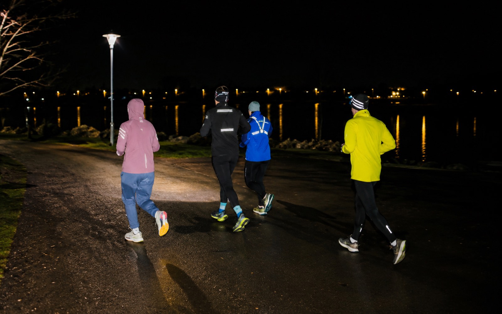 Läufer bei Nacht auf einem Waldweg mit Stirnlampe
