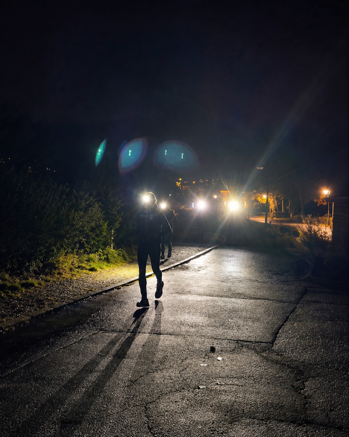 Läufer mit Stirnlampe im dunklen Wald